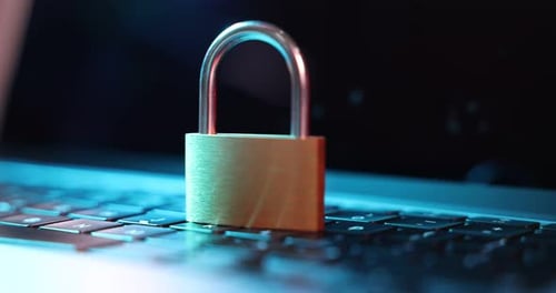 Cyber safety. Metal padlock on laptop in color lights, closeup