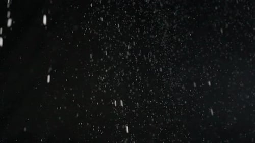 Many Dust Particles White Powder Falling From Above Floating on Empty Black Contrast Background Slow