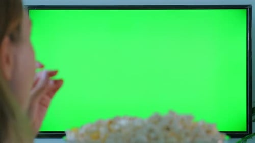 Woman Watching Green Screen TV While Eating Popcorn at Home Cinema