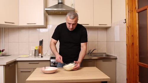 Man Mixing Ingredients in a Kitchen