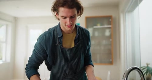 Young Adult Chopping Vegetables in Sunny Kitchen