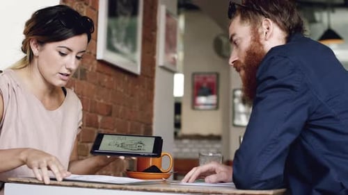 4k video footage of two businesspeople having a discussion at a cafe