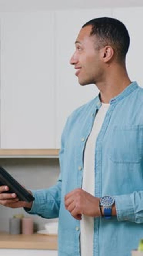 Young Adult Using a Tablet in Modern Kitchen