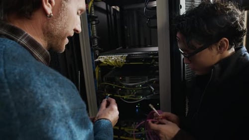 Data Center Engineers Discussing Server Installation with Network Cables