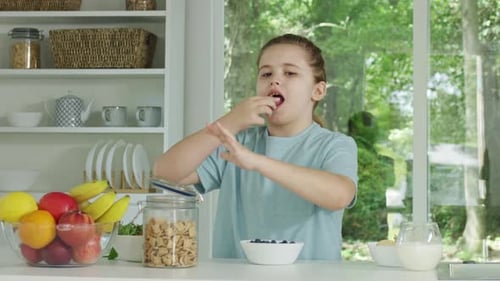 Young Girl Eating Breakfast in Sunny Kitchen