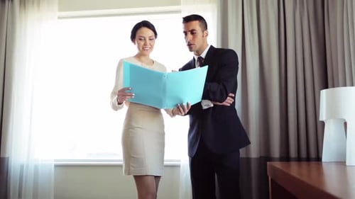 Business Trip, People and Work Concept - Man and Woman with Papers