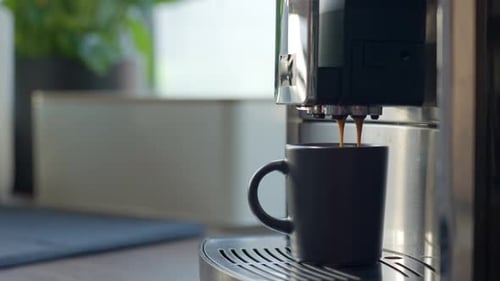 Espresso Machine Brews Coffee into Mug in Kitchen