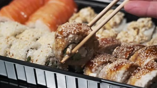 Sticks Put Sushi Roll in the Plastic Sushi Box CloseUp