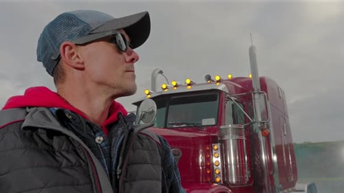 Truck Driver at Sunset Near His Big Rig in a Scenic Location