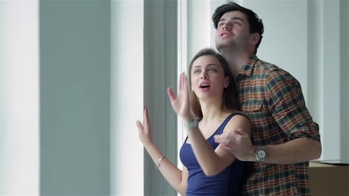 Couple in Love Standing at the Window Among Boxes