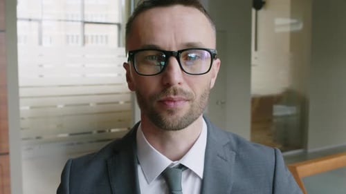 Porträt einer kaukasischen Führungskraft mit Brille, die in die Kamera blickt