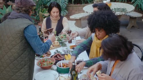 Friends Share Food Outdoors During a Meal