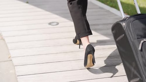Business Woman Walking With Rolling Suitcase Outdoors