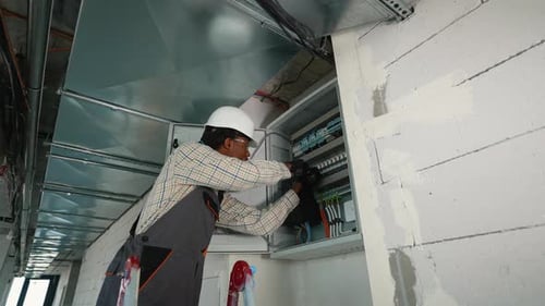 Skilled Electrician Inspecting Building's Electrical Panel Wiring