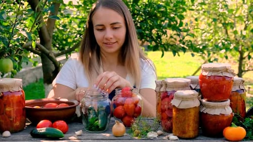 Woman with Canned Food and Vegetables in the Garden Selective Focus