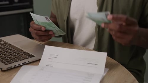 Euro Banknotes and Laptop at a Table