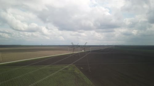 Vue aérienne des lignes électriques au-dessus d'un champ agricole vert