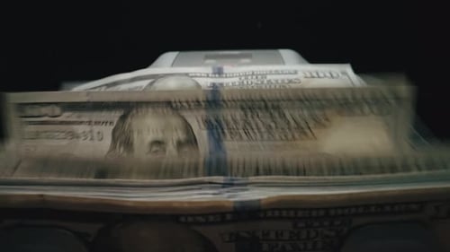 Bill Counter Pushing One Hundred US Dollar Bills Into a Stacker