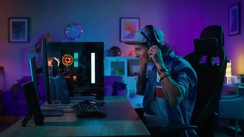 Young Man Gaming at Powerful Computer in Colorful Room