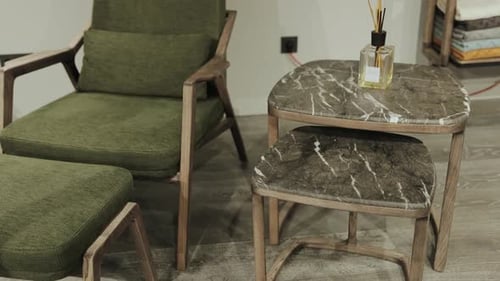 A Beautifully Designed Elegant Green Chair Accompanied By a Stylish Marble Side Table Set
