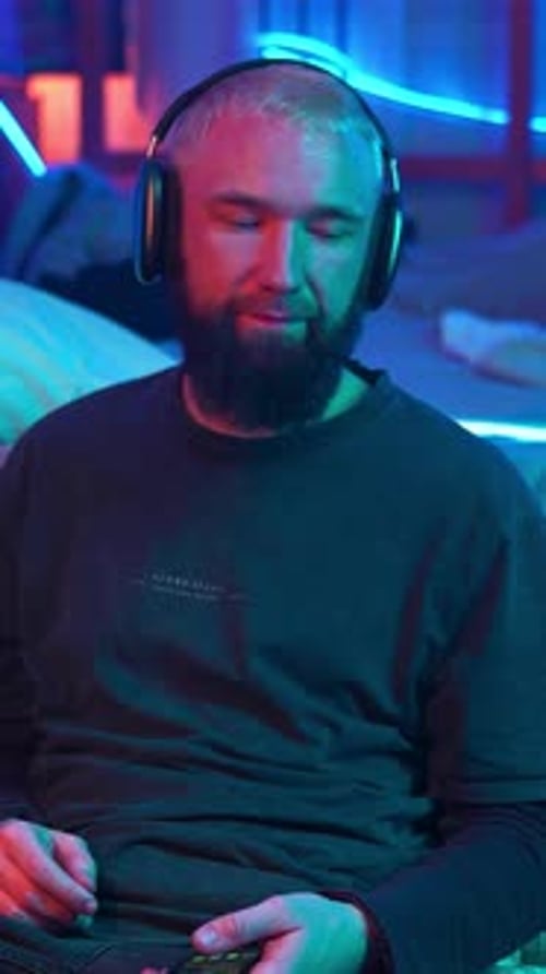A Guy in a Neon Room Listening to Music Alone and Relaxing Media Room of a Teenager and Mess