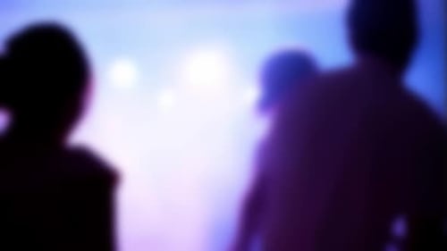 Blurred silhouettes of people dancing at party