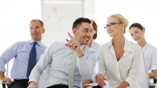 Happy business team applauds presentation at corporate seminar in modern office