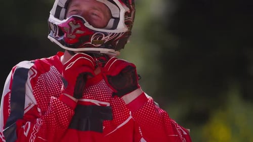 Motocross Rider Secures Helmet, Prepares for Race
