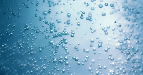Many water bubbles in blue water close up, abstract water wave with bubbles in slow motion.