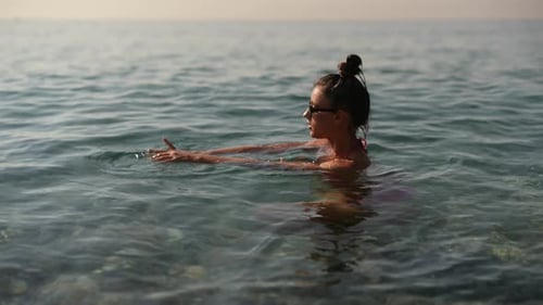 Woman Swimming in the Ocean on Sunny Day