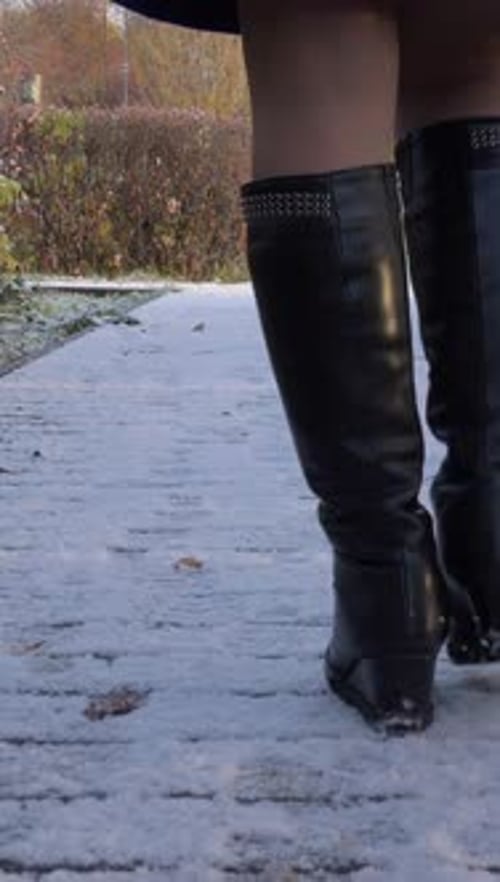 Woman is Walking on Snowy Path Legs Closeup Vertical Video