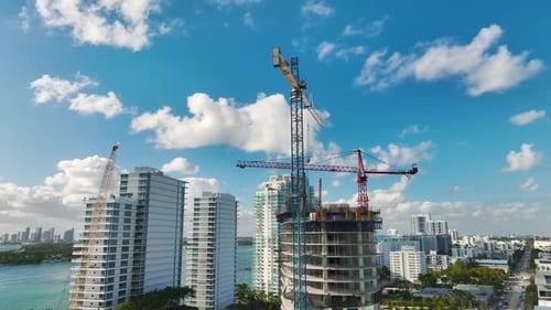 Tower Lifting Cranes at High Residential Apartment Building Construction Site Real Estate