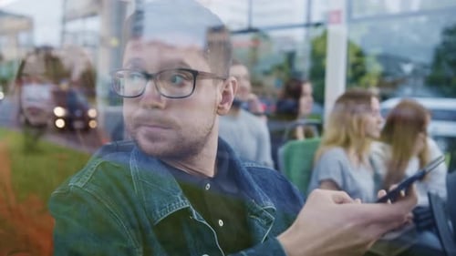 Man Using Smartphone on a City Bus