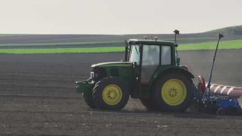Tractor Planting Seeds in Rural Farm Field