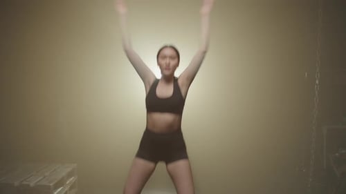 Active Motivated Sporty Fit Asian Female Doing Jumping Jacks Exercise in Gym