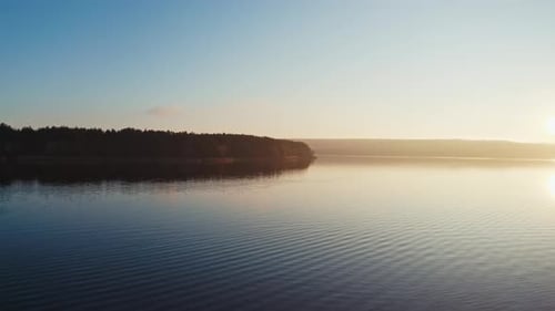 Evening river among nature.Tree without leaves over the water at sunset. Dark forest near the lake.