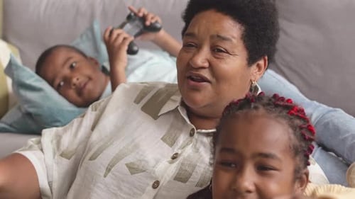 Family Enjoys Video Game Together on Couch