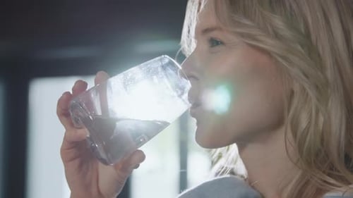 Close Up Portrait Woman Drink Water From Glass Indoors Sunshine Stand in Room Smiling Water Balance