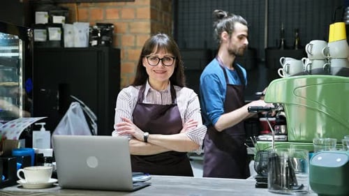 Female Business Owner in Apron Standing Behind Bar Counter in Coffee Shop Cafeteria