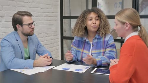 Corporate Team Discussing Charts in Modern Office