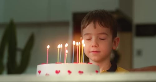 Boy Making Birthday Wish at Home, Close Up