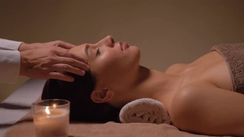 Woman Relaxing During Head Massage in Spa Setting