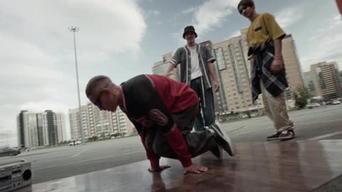 Un adolescent B-Boy sort à l'extérieur avec des amis en milieu urbain