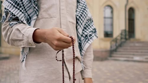 Person Holding Prayer Beads in Hand