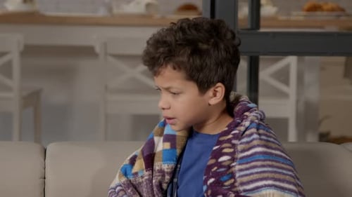Boy Coughing and Blowing Nose Wrapped in Blanket