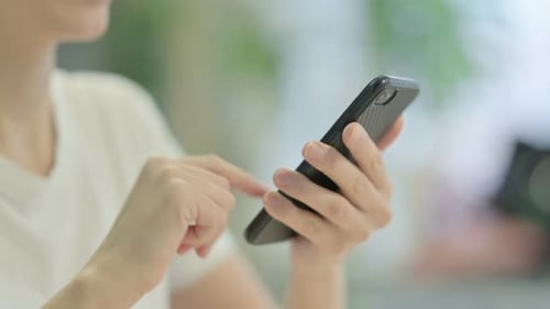 Close up of Casual Young Woman Browsing Internet on Smartphone