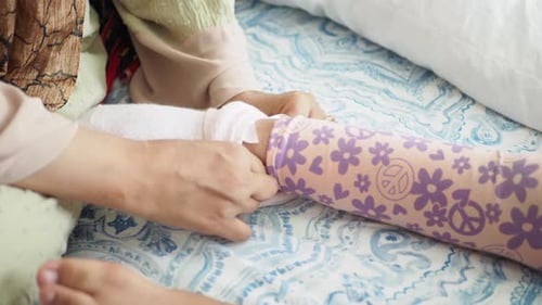 Woman wraps bandage around child's leg