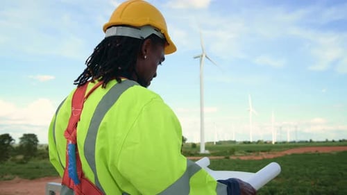 Smart engineer with protective helmet holding the blueprint working