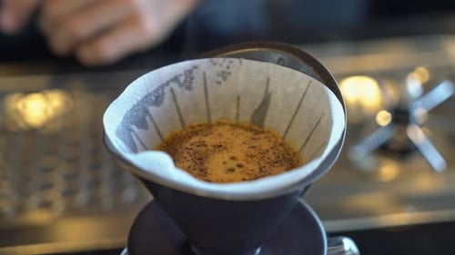 Pouring Hot Water Over Coffee Grounds in Filter