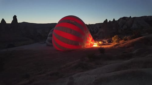 Heating hot air balloon before scenic sunrise flight in Cappadocia, Turkey